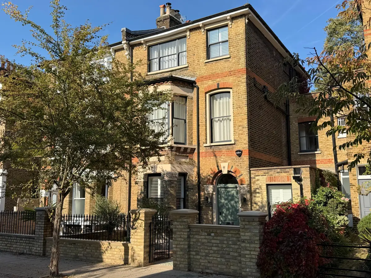 Victorian semi-detached house in London stock brick with a bay window, sash windows and a new front garden wall and railings